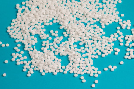 Sugar pills blue background. Medical pills close-up.