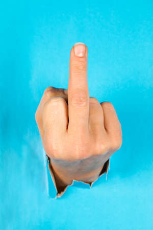 Hand through the torn blue paper. gesture