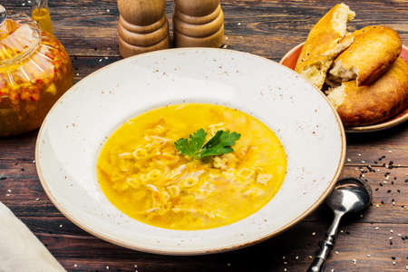 The image of a bowl of traditional chicken soup served in a bowl on wooden backgroundの写真素材
