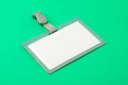 Blank security tag with a red stripe neck on a green background. Place for text, layout.