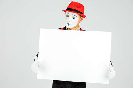 happy MIME artist holding a blank white Board, on a white backgroundの写真素材