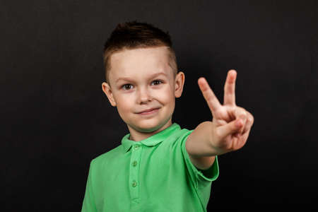 Handsome guy shows hand gesture isolated on black background. Studio portrait. Men's emotions