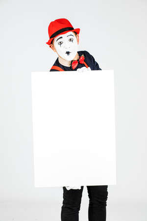 happy MIME artist holding a blank white Board, on a white backgroundの写真素材