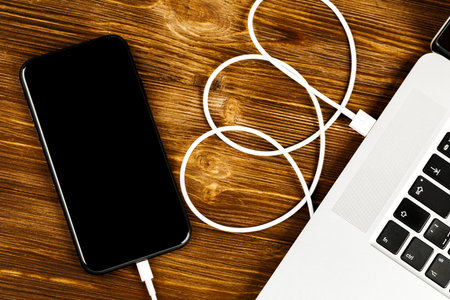 A USB cable connects your phone and laptop.