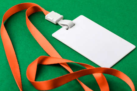 Blank security tag with a red stripe neck on a green background. Place for text, layout.の写真素材