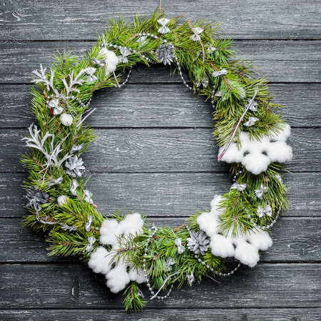 Christmas wreath with ornaments on black wooden backgroundの写真素材