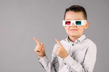 Young handsome boy with 3d glasses on grey background in Studioの写真素材