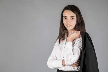 Portrait of a business woman. Cross his arms. on a gray background.の写真素材