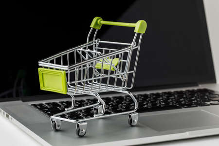 Online shopping and e-Commerce. Basket and laptop on white backgroundの写真素材