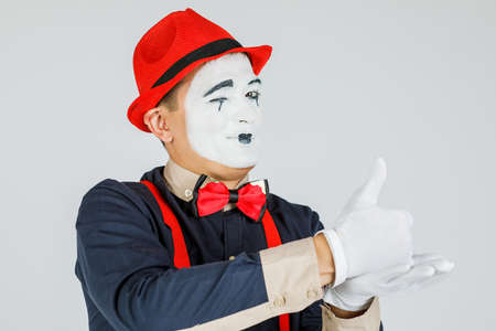 A MIME artist does tricks with his hands. Funny MIME show, a talented actor. Isolated on white backgroundの写真素材