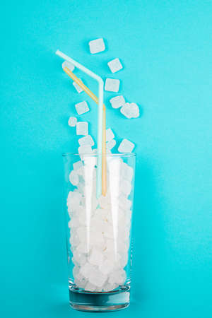 Glass of sugar. The concept of junk food. On red backgroundの写真素材