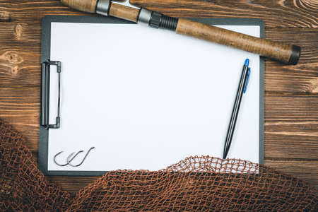 Fishing tackle-fishing, pen, hooks, wooden background.