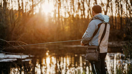 A man fisherman fishing in the river with a fishing rod