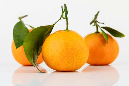 Ripe Mandarin with leaf close-up on white background.の写真素材