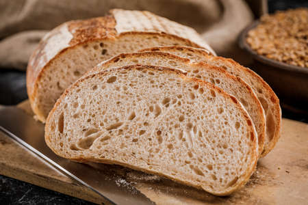 Freshly baked bread cut into chunks on a wooden Board.