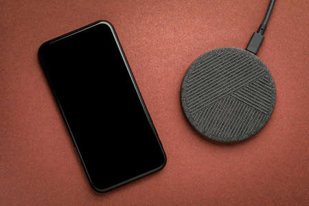 The smartphone is charged by a wireless charger  Concept of new technologies