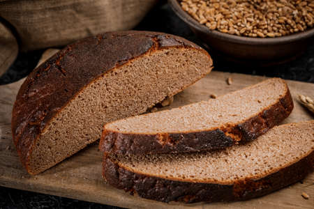 Freshly baked bread cut into chunks on a wooden Board.