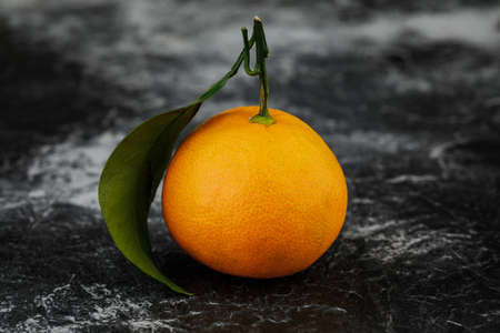 single tangerine on marble background.