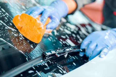 A man washes a soap white car. Cleaning concept.の写真素材