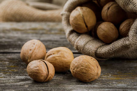 bag with walnuts on wooden table.