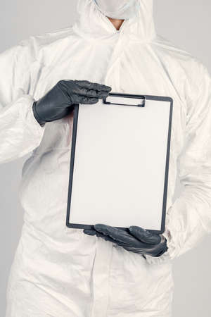 A man in a uniform and face mask holding a placard. Concept of healthcare and medicine.の写真素材