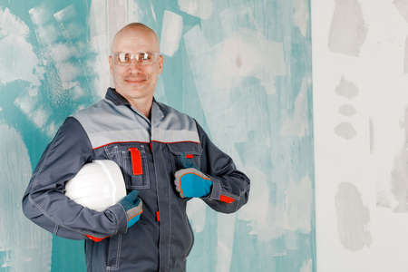Portrait of a Builder on a rough concrete wall. Concept of construction and repair