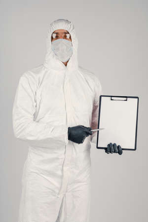 A man in a uniform and face mask holding a placard. Concept of healthcare and medicine.の写真素材