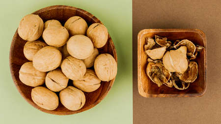 plate with some raw walnuts and peel.