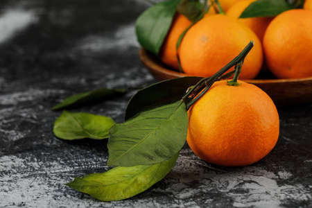a plate with some tangerines on marble background.