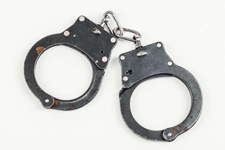 A pair of handcuffs isolated on a white background.