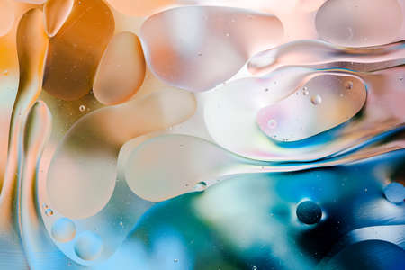 Close-up of the movement of oil droplets on the water surface. Colorful abstract macro background of oil drops on the water surfaceの写真素材