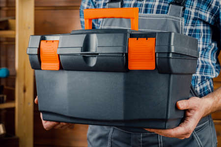 Construction and repair - a male worker or Builder with working tools in a box.の写真素材