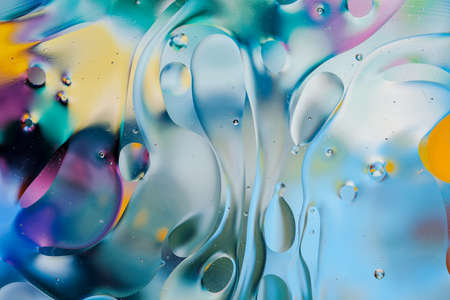 Close-up of the movement of oil droplets on the water surface. Colorful abstract macro background of...