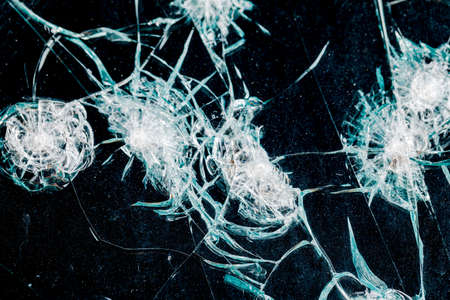 Cracks in car glass on a black backgroundの写真素材