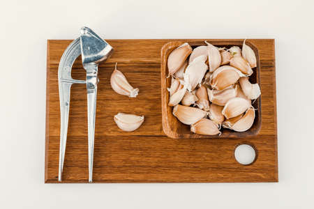 a plate of garlic with squeeze and cutting board isolated on white background.の写真素材