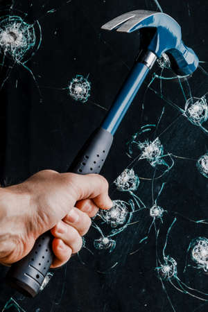 hammer in the man's hand smashes against the glass.の写真素材