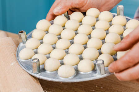 The cook in the kitchen makes dumplings. The concept of cooking.の写真素材