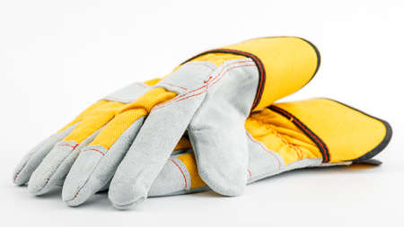 pair of yellow construction gloves on a white insulated background.