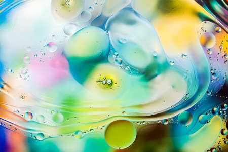Close-up of the movement of oil droplets on the water surface. Colorful abstract macro background of oil drops on the water surfaceの写真素材