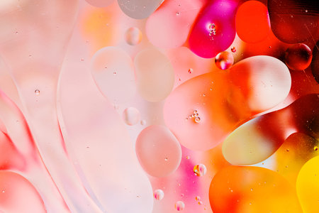 Close-up of the movement of oil droplets on the water surface. Colorful abstract macro background of...