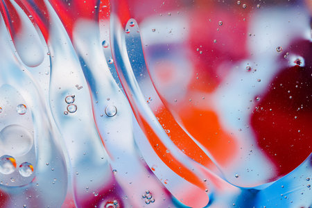 Close-up of the movement of oil droplets on the water surface. Colorful abstract macro background of...