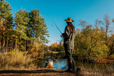 Woman fishing on the river. Fishing on a spinning rod.の写真素材