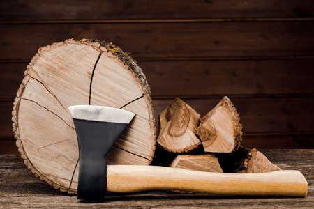 Ax and firewood, against the background of wooden boards.