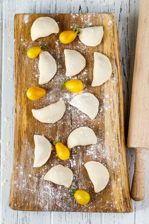 Raw dumplings, frozen homemade dumplings, on a wooden Board.の写真素材