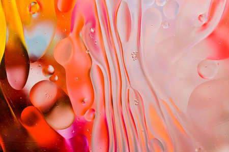 Close-up of the movement of oil droplets on the water surface. Colorful abstract macro background of oil drops on the water surfaceの写真素材