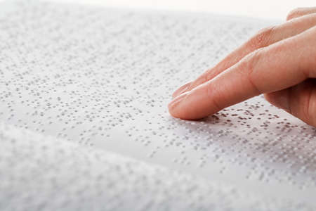 A woman reads a book written in Brailleの写真素材