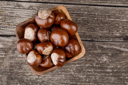 Chestnuts on an old wooden table.の写真素材