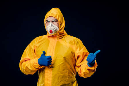 A man in a protective suit on a black background. Protection against virus outbreaks.の写真素材