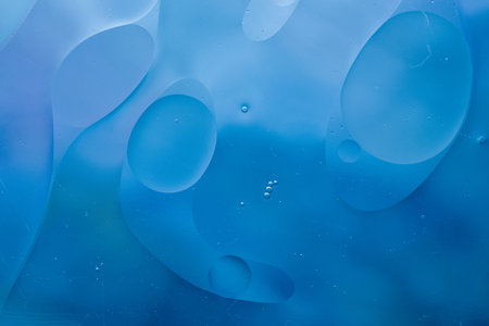 Close-up of the movement of oil droplets on the water surface. Colorful abstract macro background of...