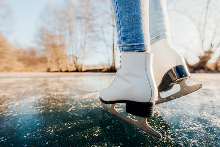 Young woman skating outdoors on a pond on a frosty winter dayの写真素材